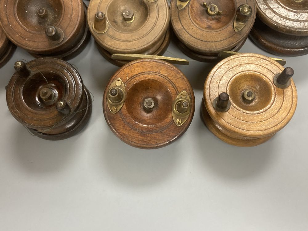 A collection of mahogany and brass fishing reels, largest 17.5cm (14)